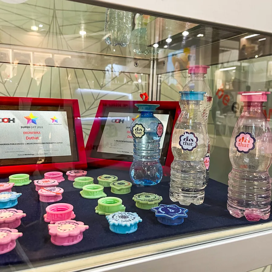 Colourful dothat Ekonewka caps in a display case next to Super Gift statuettes