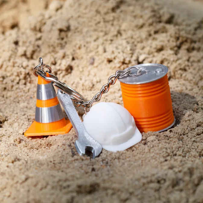 Przestrzenne breloki reklamowe 3D – miniaturowy pachołek, kask, klucz i puszka farby
