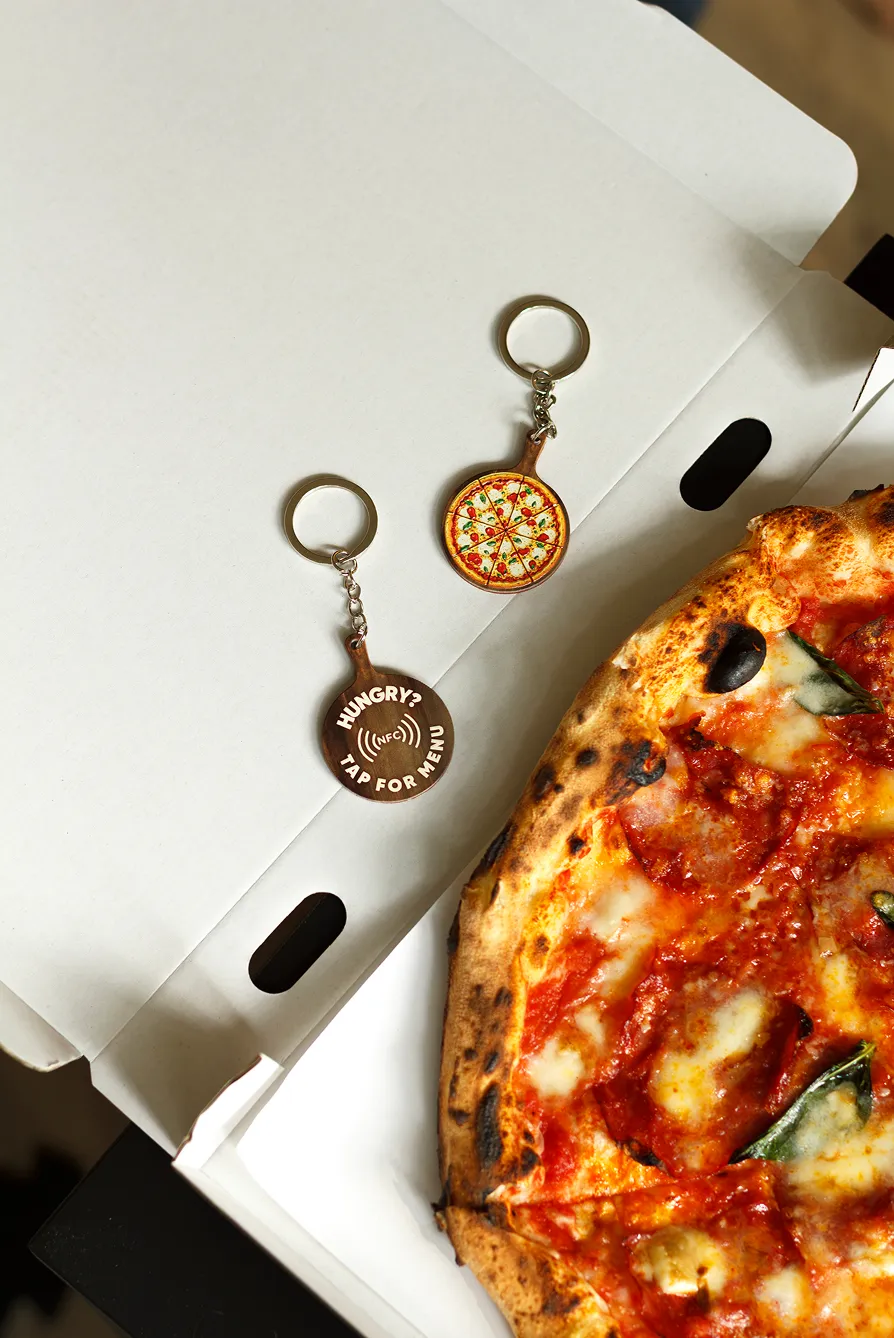 Brelok NFC pizza na otwartym pudełku z pizzą
