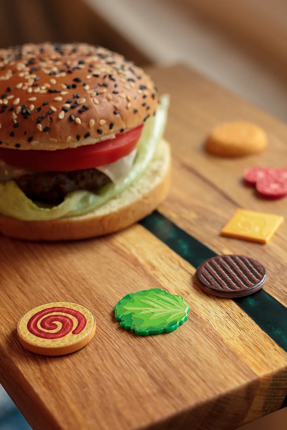 Warstwy magnesu burger rozłożone na desce obok prawdziwego burgera